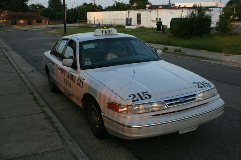 A taxicab driver sleeping on Fayetteville Street in the early morning in Durham, North Carolina.