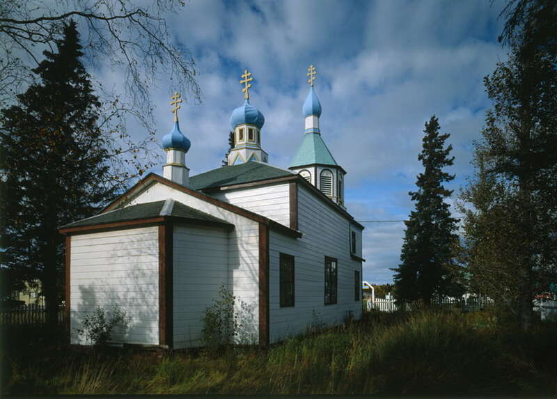 One of the oldest Russian Orthodox churches in Alaska, Holy Assumption Church has a high, square, pyramidal-roofed nave framed by two gable-roofed sections. The belltower, 81' to the top of its cross, was added five years after initial construction.