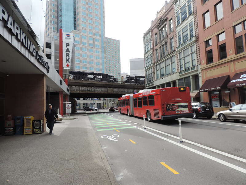 Looking southwest behind the bus station at 2-way bike lane and passing train.