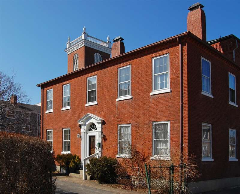 Bessie Monroe House, historic building at 7 Ash Street, Salem, Massachusetts, est. 1811. Steeple of First Universalist Church visible in background.