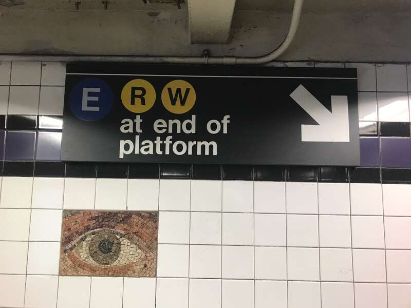 A sign at the Chambers Street IND station, pointing downward to a platform, and to the then-new transfer to the Cortlandt Street BMT station. Also visible is detail of the station-wide art installation "Oculus".