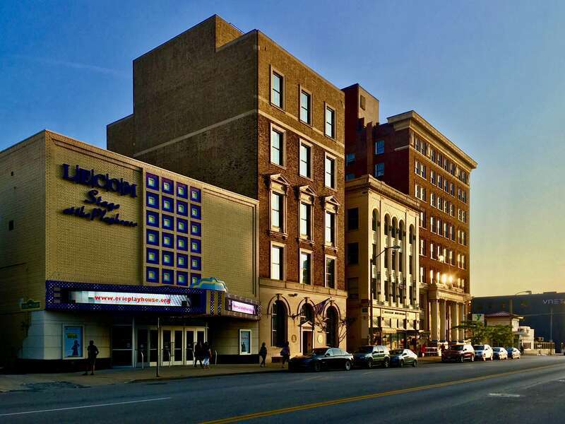 A row of brick buildings on West 10th Street in downtown Erie, Pennsylvania are illuminated by the setting sun.