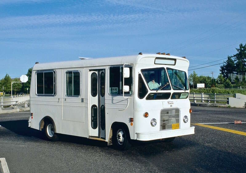 TriMet minibus No. 69, a "Flxette" model (manufactured by the Flxible Company), in service on a short-lived, unnumbered TriMet route between the Cedar Hills Transit Center and the Oregon Graduate Center, via Tanasbourne Mall.  The minibus is turning