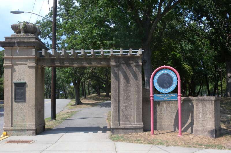 Looking north at eastern walk gate of southern entrance of Gregg Park on a sunny midday.