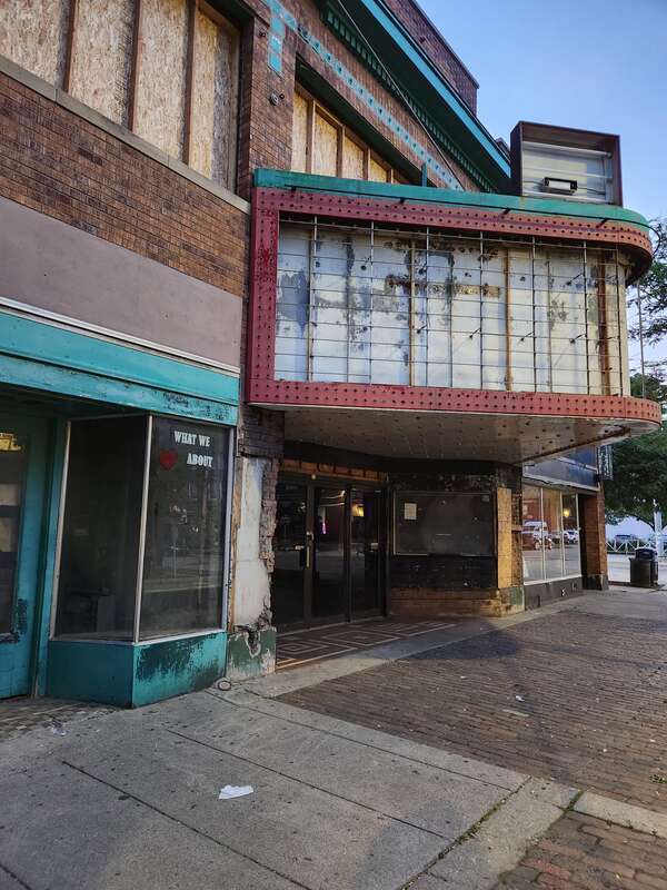 The former Martha Washington Theatre, now the Deja Vu Showgirls club, seen from the sidewalk on a July evening. Windows are boarded up and signage has been removed from the marquee, following a major fire and the beginnings of a renovation program.