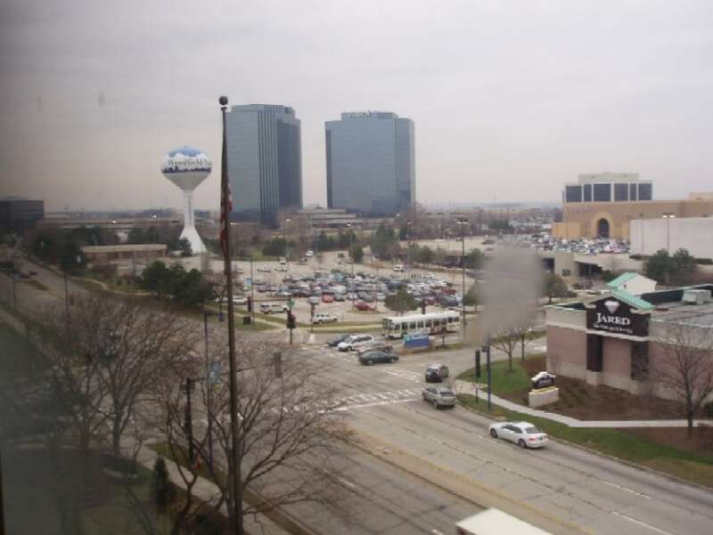 Schaumburg: NW across Woodfield Rd. at Mall Dr., across Woodfield Mall SW parking lot, with water tower to the left; Zurich/executive highrises on Plaza Dr in background