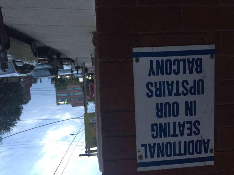 A sign posted on a building in Southern New Hampshire that reads, "ADDITIONAL SEATING IN OUR UPSTAIRS BALCONY"