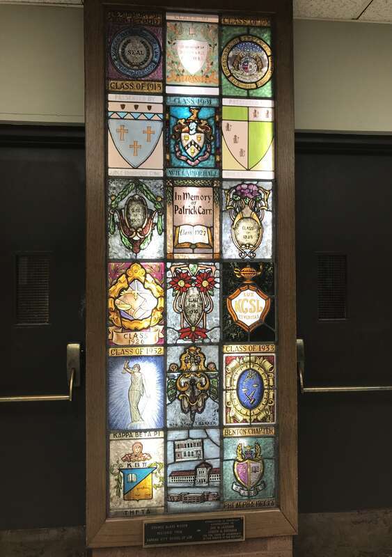 Stained glass window inside the UMKC School of Law depicting various classes and locations throughout the law school's history.