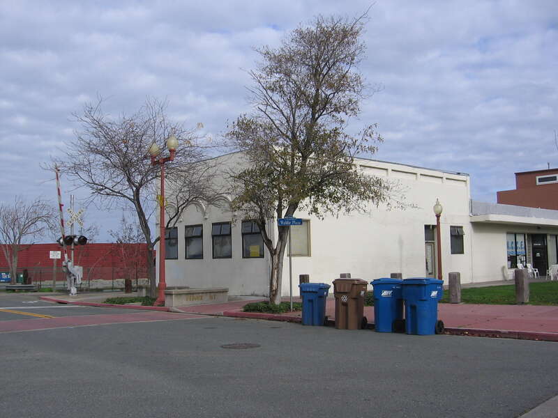 Building at 1-99 I Street in Antioch, California.  This older, vaguely art-deco styled building sits adjacent to the former AT&amp;SF tracks in Antioch.  A gate arm for the I Street grade crossing is visible to the left of the building, which sits