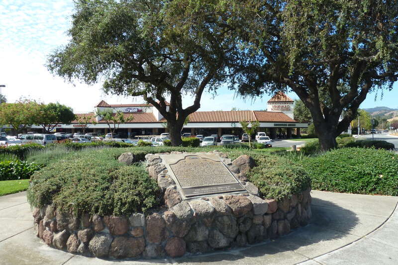 Bronze interpretive plaques and oak trees at site of 21-Mile House, a 19th-century inn and stage coach stop, at intersection of Monterey Street and Tennant Avenue in Morgan Hill, Santa Clara County, California, U.S.A.  California Registered Historic