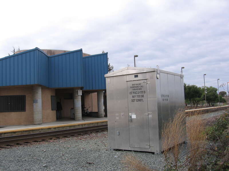 The Antioch–Pittsburg (Amtrak station) in Antioch, California, USA. View is looking southwest from the Riverview sidewalk.  Note the BNSF stencil on the signal box - indicating that this was the AT&amp;SF line in the past (the former SP [now UPRR]