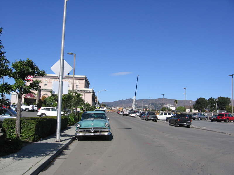 The Artichoke Joe's Casino in San Bruno, California, USA.  The Casino is the building on the left side of the street.  There is an old model Ford car parked along Huntington Avenue, and a project to elevate the Caltrain tracks over Angus Avenue and