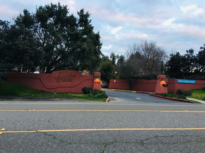 Main front sign of Davis Waldorf School on the left, vehicular entrance to the school on the right