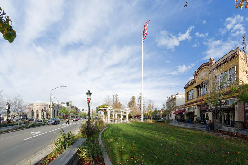 The flagpole in downtown Livermore, California has been a community landmark since 1905. The Howard replica clock (c. 1900) on the left was installed in 1995 as a memorial for Robert L. Howard. Also on the left is the Bank of Italy building which was