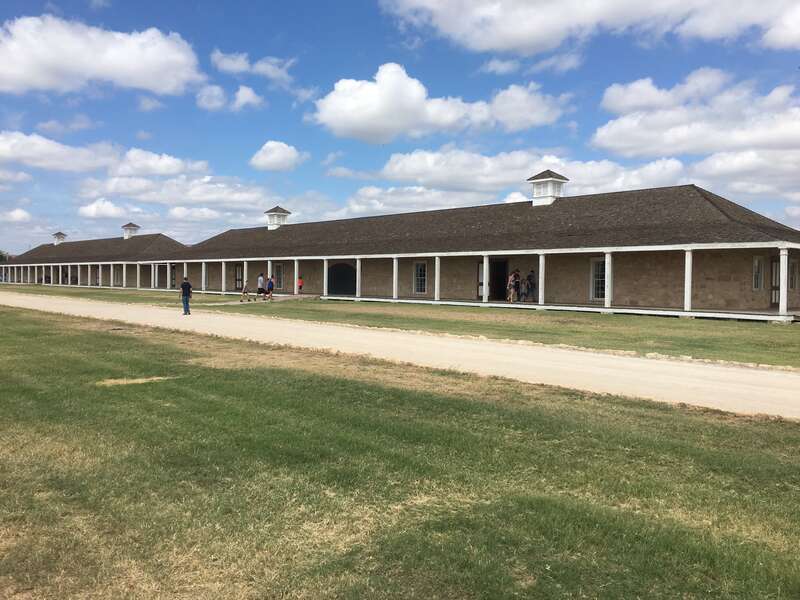 Fort Concho's first and second enlisted men's barracks. The first building (far left) contains the visitors center while the second is an exhibit of period artillery and wagon pieces.