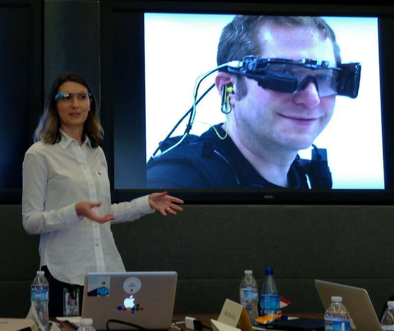 Sarah Price from Google X sports the current model and shows the development history today at Google HQ.   Here you see pioneer Thad Starner with the first prototype.  It needed a backpack for the batteries. More below.
The display is up and to the