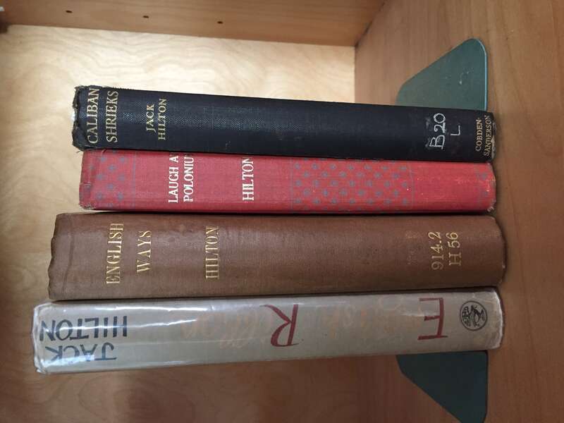 A collection of Hilton's books, on a shelf