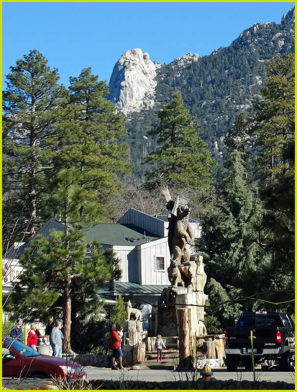 (1 in a multiple picture set)
Two of Idyllwild's landmarks are shown in this picture.  On top is Tahquitz Rock, and at the bottom is the very well done wood sculpture called "Harmony." It shows all the different species of wildlife in the area living