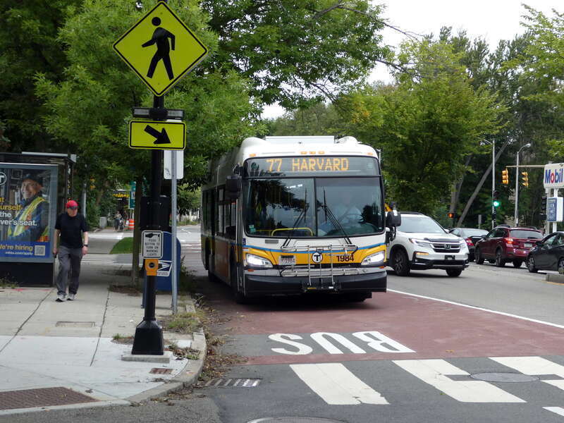 MBTA route 77 bus at Magoun Street, with a red bus lane, in September 2022