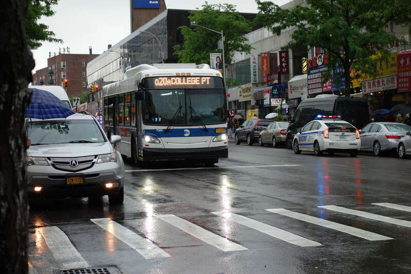A College Point–20th Avenue-bound Q20A local bus stopped at a light at Main Street and 41st Road in Downtown Flushing, Queens.