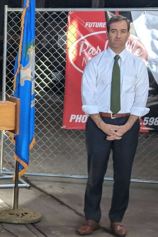 Luke Bronin standing next to a Connecticut state flag.