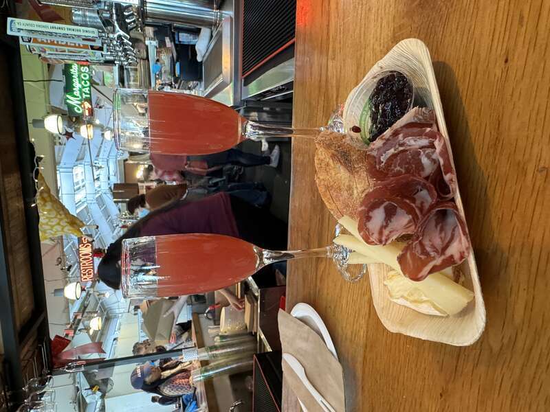 Cheese and charcuterie board with two blood orange mimosas at the Oxbow Cheese &amp; Wine Merchant.