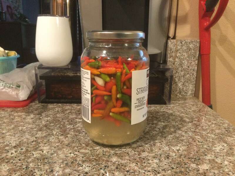 A jar full of pickled chilies on my kitchen of my house. This is our own chili pickles.