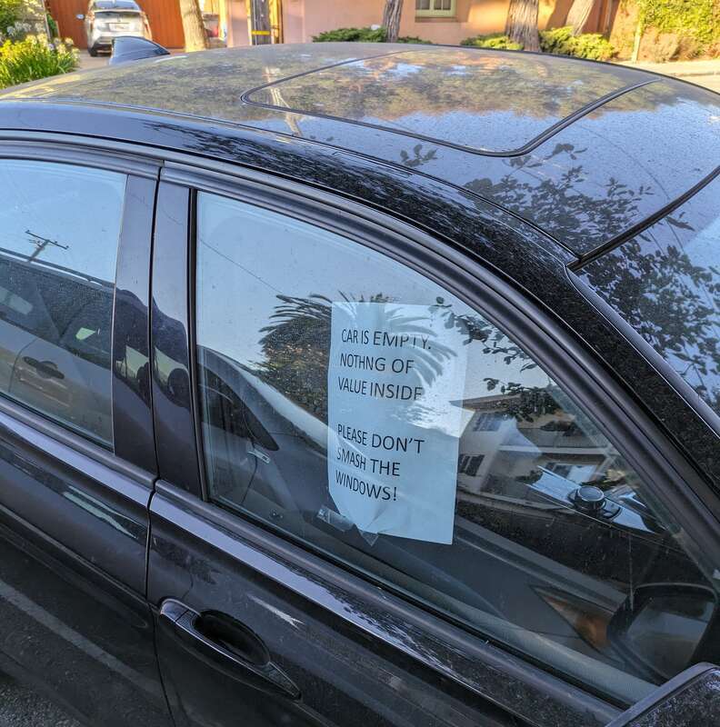 A car in Oakland, California, United States, with a sign in the window saying "CAR IS EMPTY. NOTHING OF VALUE INSIDE. PLEASE DON'T SMASH THE WINDOWS!"