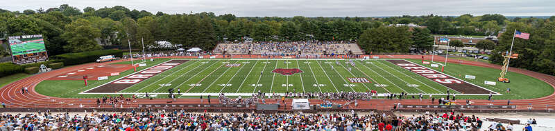 A wide view of Richard Gouse Field at Brown Stadium (Brown University, Providence Rhode Island). View from the main grandstand toward the field and the visitors stands. Scoreboard at left. Brown Football vs. URI, 18 September 2021. This was the first