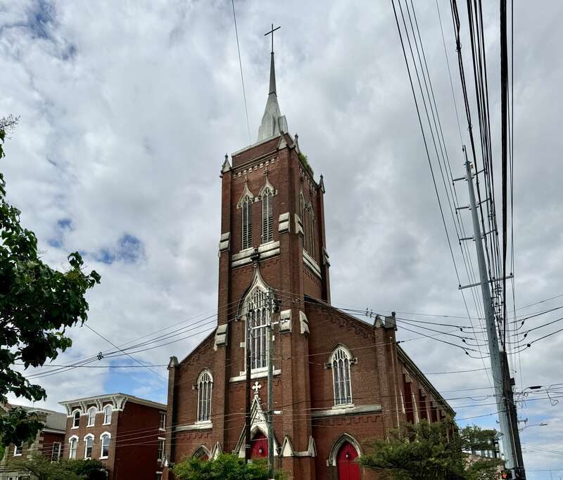 Built in 1866-1867, this Gothic Revival-style building was constructed for St. John’s German Evangelical Church, which later became the St. John United Church of Christ.  The building features a red brick exterior, stone trim, a gable roof, brick