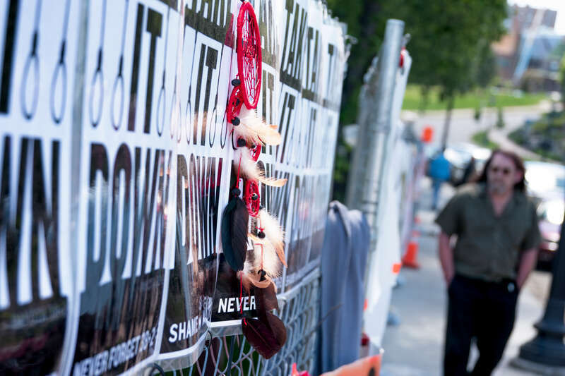 Take It Down signs and dream catcher along the perimeter fence of the Minneapolis Sculpture Garden in response to Sam Durant's "Scaffold" sculpture.
Photograph by Lorie Shaull.
"Scaffold," a wood &amp; steel sculpture by the artist Sam Durant, was a