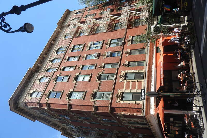 Looking southeast across West 4th at apartment building on a sunny afternoon