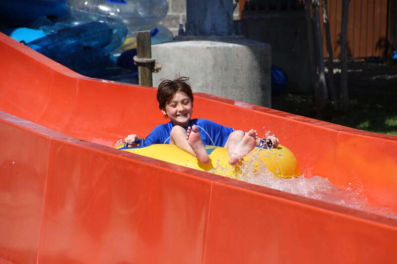 Boy riding a water tube slide ride at a water park.