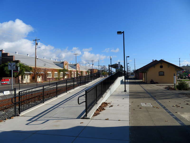 The west ramp to Petaluma Downtown station in December 2019. A small building, likely the former express or baggage office, is at right.