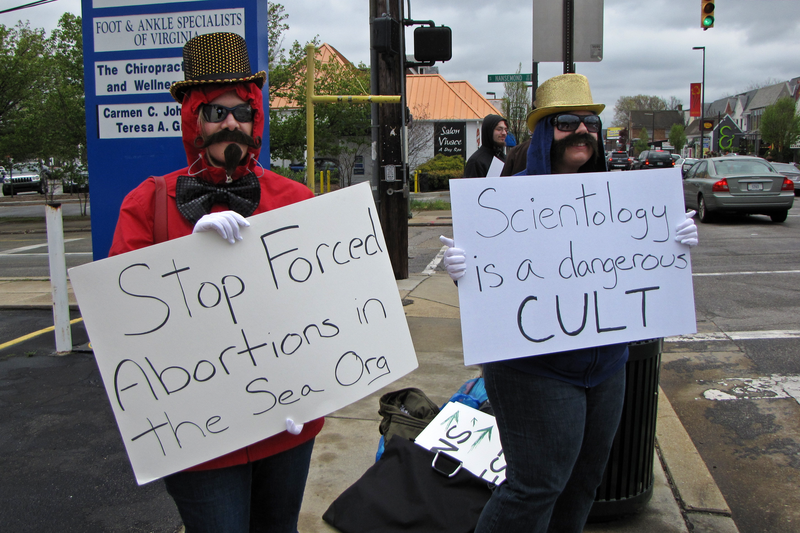 "Anonymous" demonstrators from Washington, DC protest the practices of the Church of Scientology at the organization's Richmond facility.  Due to an anti-mask law in Virginia, demonstrators used fake mustaches and sunglasses instead of Guy Fawkes