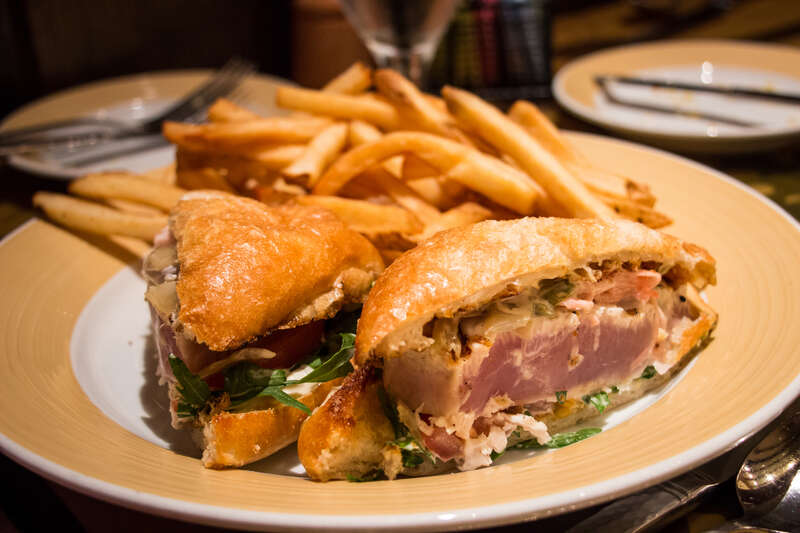 Michelle's entree at Storyteller's Cafe: Grilled Albacore Tuna (Rare) - Lightly seasoned with a zesty Lemon-Caper Mayonnaise, topped with fresh Arugula, Tomato, Caramelized Onions, and Pickled Ginger served with French Fries.
