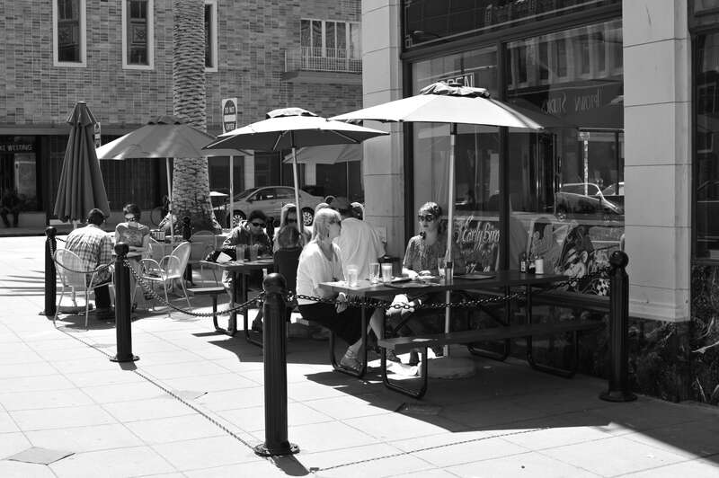 Patrons enjoy brunch on Saturday morning in downtown Oakland outside on the sidewalk.

The man sitting across the street can be seen laughing in another photo.