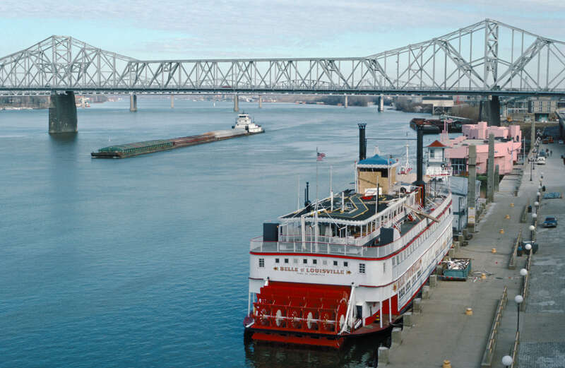 Looking ENE from Belvedere between 4th and 5th Sts.
Steamer "Belle of Louisville" (doc. # 212813) docked at wharf near foot of 4th St.
Pink barges near 3rd St. are Splash bar and Islands restaurant.
Towboat "Dakota Storm" (doc. # 282986) downbound at