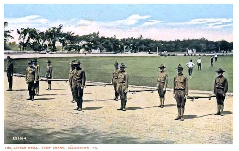 This colorized photo postcard shows stretcher bearer training on the horse racing track of Camp Crane.   Each litter had two men, one on each end.  They carefully helped wounded soldiers onto the stretcher litter, and the men transported the solder