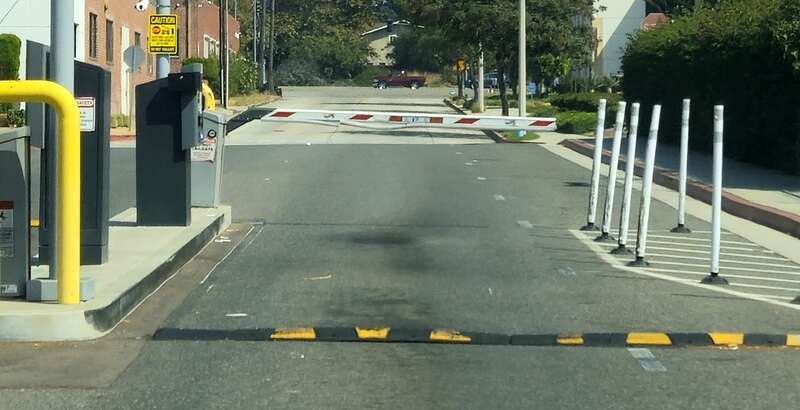Boom barrier in closed position at the exit to a 0apay parking lot.