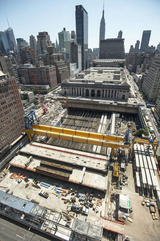 Giant cranes and boring machines work in tight quarters with the Long Island Rail Road’s 24/7 operations at the LIRR west side storage yard to construct the platform that will support the office towers, apartments and shopping center of a new