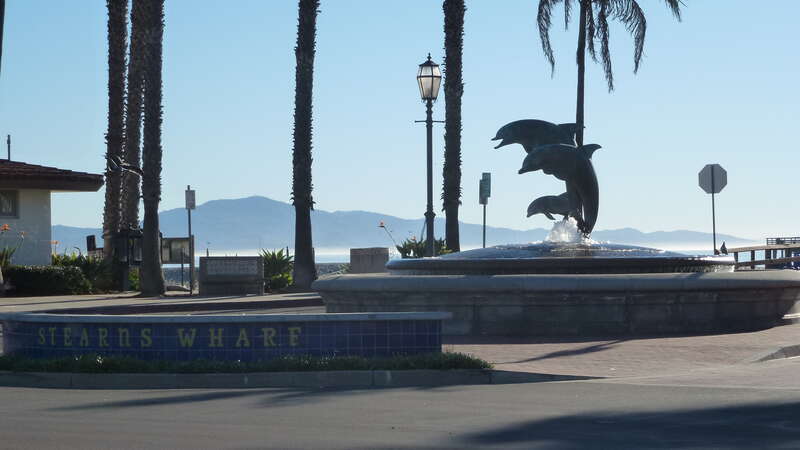 The entrance to Stearns Wharf features a fountain with a statue of dolphins