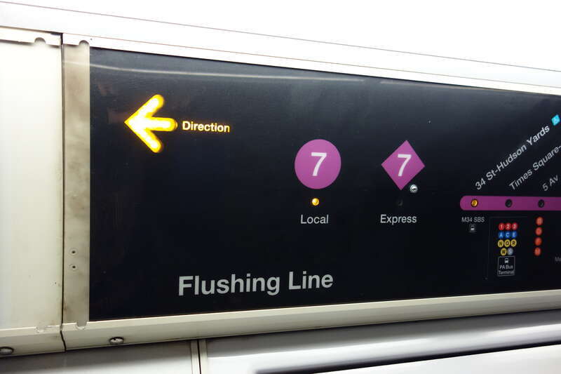The interior of an R188 train in 7 service, taken on the IRT Flushing / 42nd Street line between Times Square and 34th Street – Hudson Yards in Midtown Manhattan. Pictured is the strip map, with a selector for 7 Local or <7> Express.