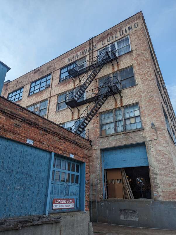 Back of the Park Trades Center, with loading dock and fire escapes. The former name of the building, Saniwax Building, is still visible.