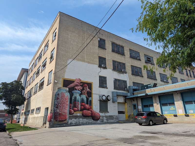 Back of the Park Trades Center, a repurposed building now dedicated to the arts. The mural features the poem "Glass Jars" by Meredith Adams.