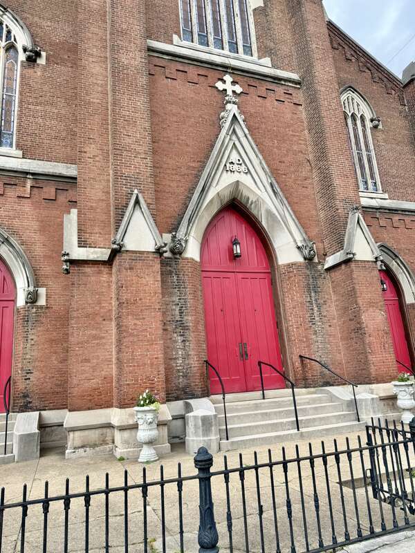 Built in 1866-1867, this Gothic Revival-style building was constructed for St. John’s German Evangelical Church, which later became the St. John United Church of Christ.  The building features a red brick exterior, stone trim, a gable roof, brick