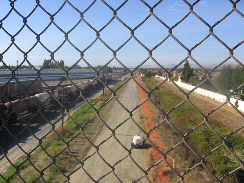 Orange construction site fencing along the right of way being prepared for the en:Silicon Valley BART extension as seen from the (northern) East Calaveras Boulevard overpass.  View is looking north-northwest.