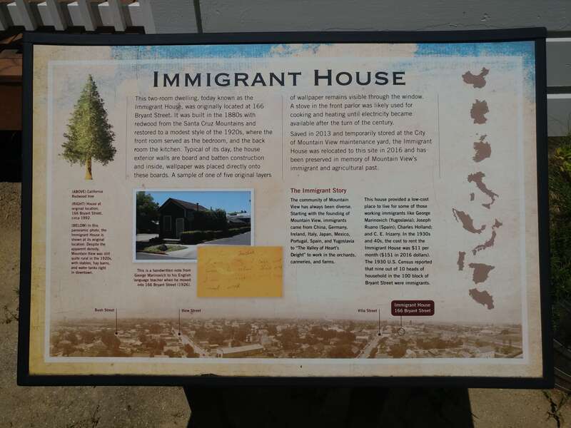A panel explaining history of the "Immigrant House" structure displayed within the park.
