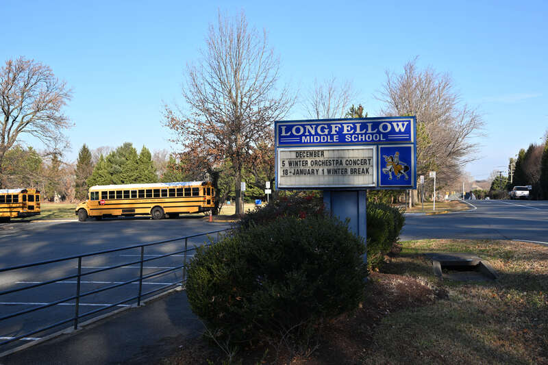 The sign on Westmoreland St. for Henry Wadsworth Longfellow Middle School with school busses parked in the parking lot. Longfellow M.S. is part of Fairfax County Public Schools. 2000 Westmoreland Street, Falls Church, Virginia 22043.