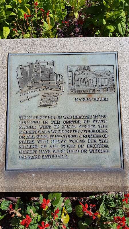 Plaque in the median of the intersection of State and Lodge streets, Albany.  The plaque reads: "The market house was erected in 1704 located in the center of State Street, west of James Street  The market was a wooden structure, open on all sides.